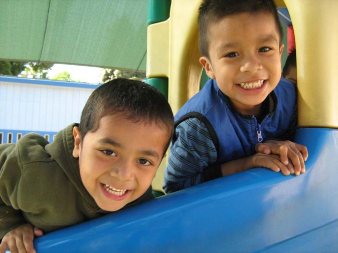 2 smiling boys on slide